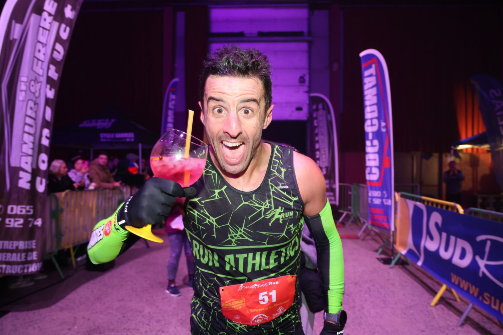 Un coureur brandissant son cocktail après la ligne d'arrivée